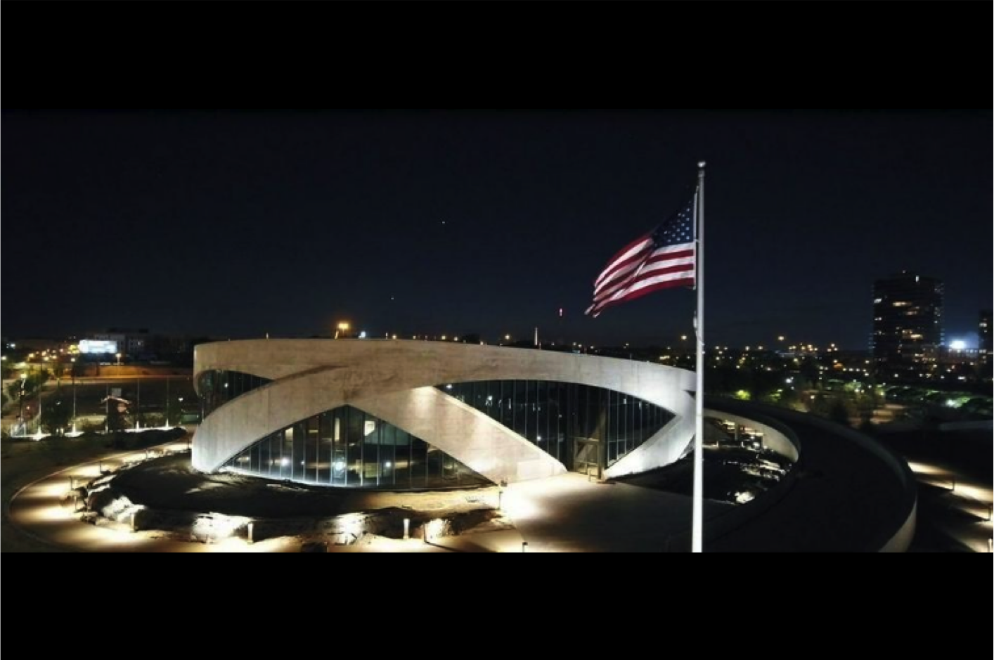 Exterior view of National Veterans Memorial Museum and American flag lit at night